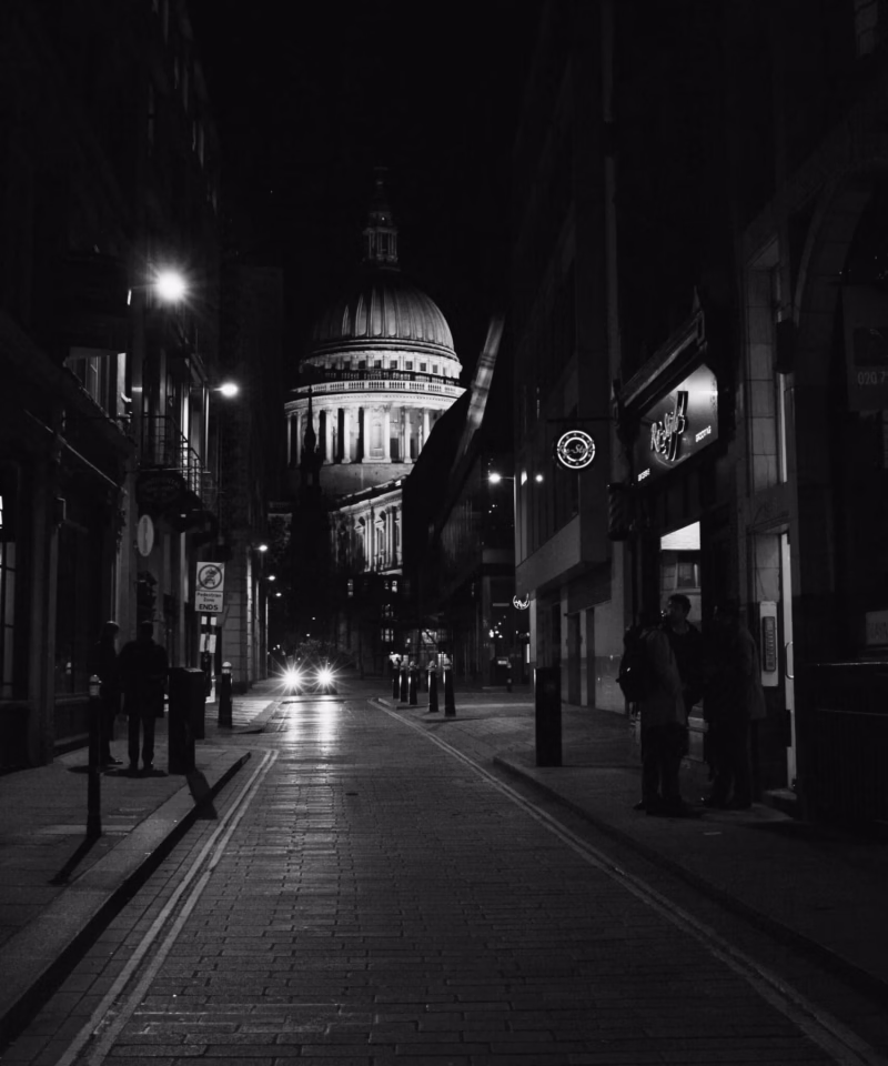 grayscale photo of empty road between buildings